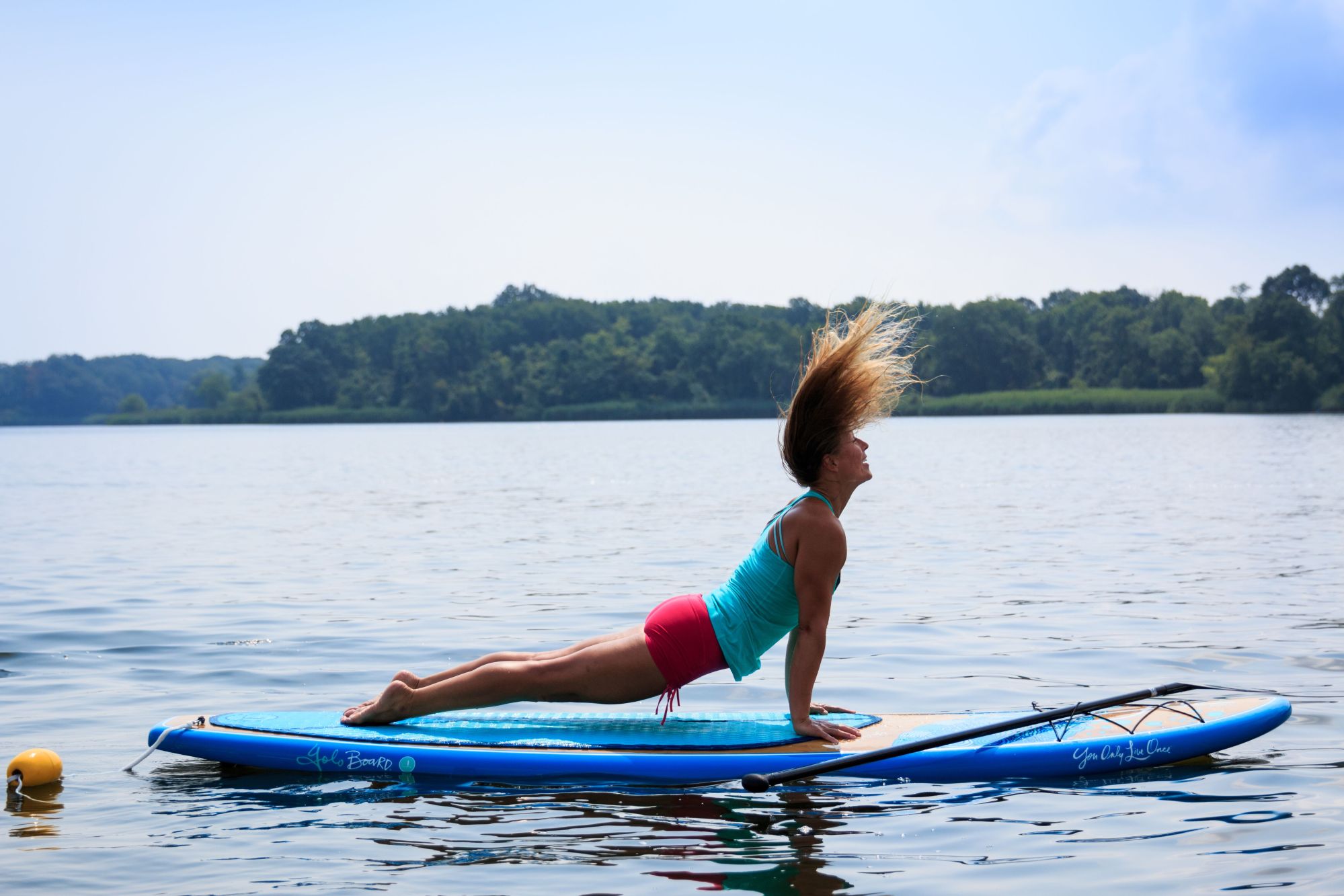 IMG_6013_preview A woman doing upward dog with her hair blowing in the wind on a SUP