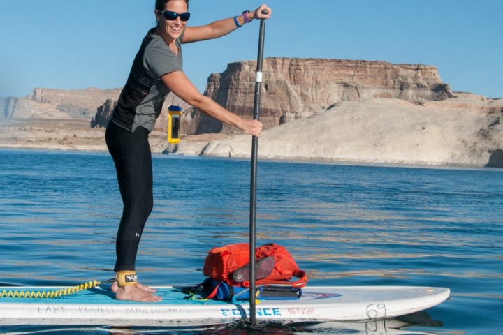 a man and a woman standing in water holding a surfboard