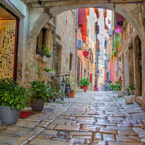 a stone building that has a sign on a brick sidewalk
