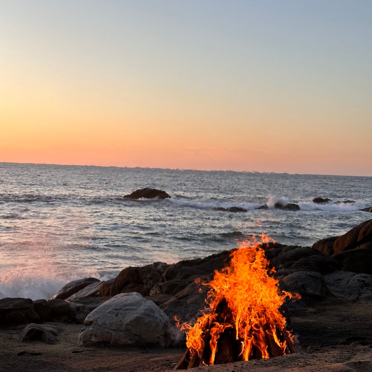 a sunset over a beach next to the ocean