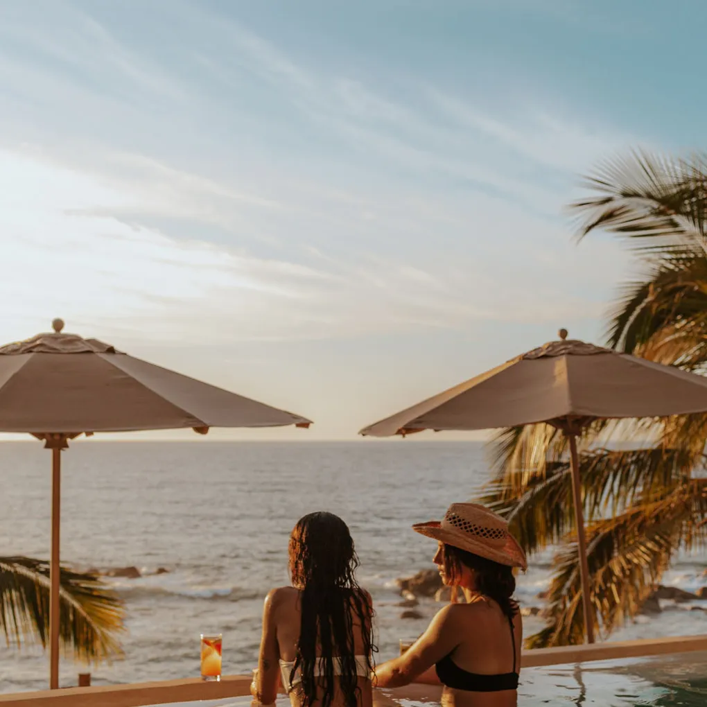a group of people standing next to a body of water