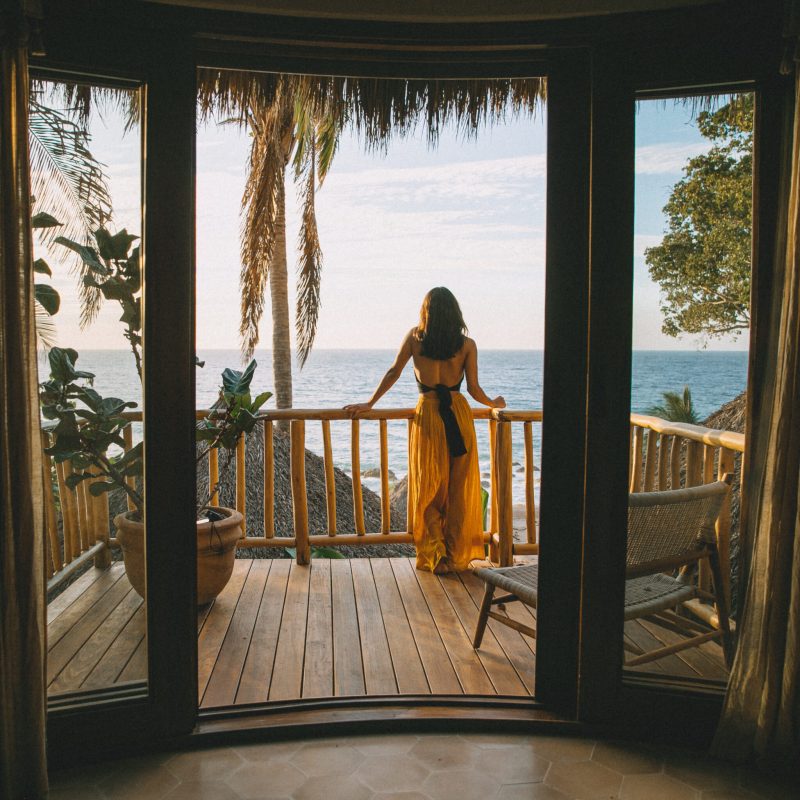 a person standing next to a body of water in front of a window