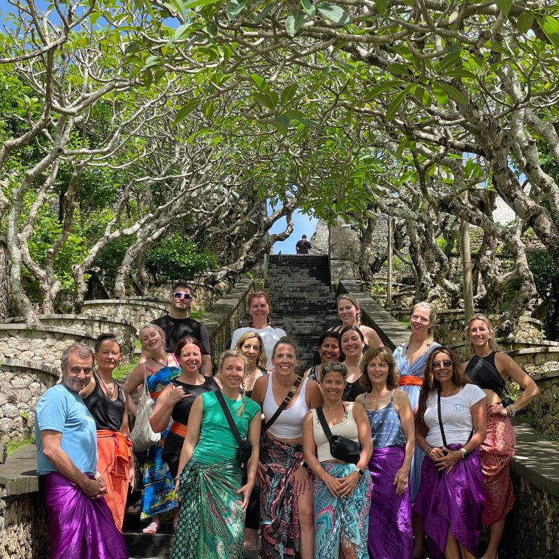 a group of people standing in front of a tree