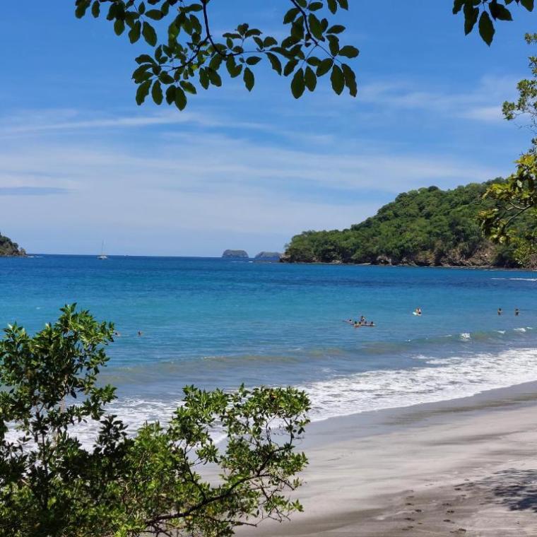 a sandy beach next to a body of water