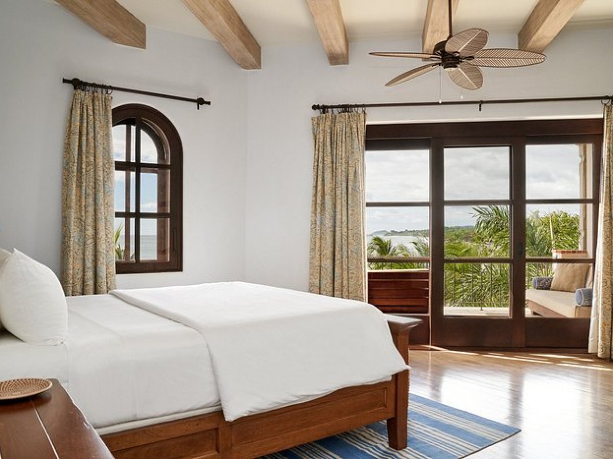 a bedroom with a bed and a chair in a room