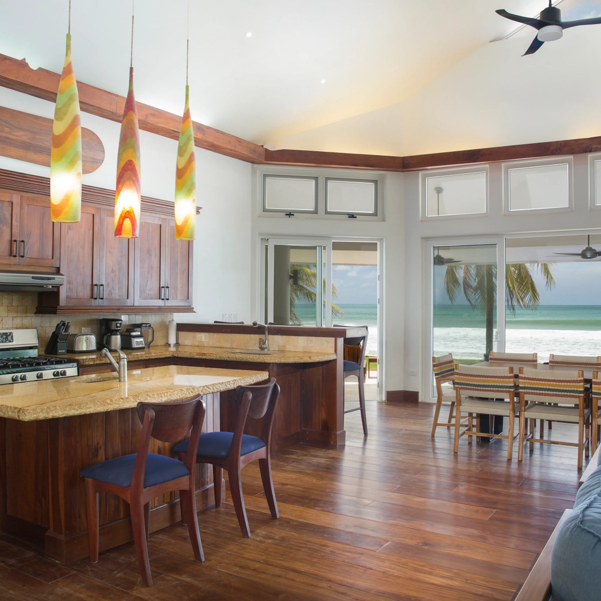 Open-plan kitchen and living area with ocean view through large windows.