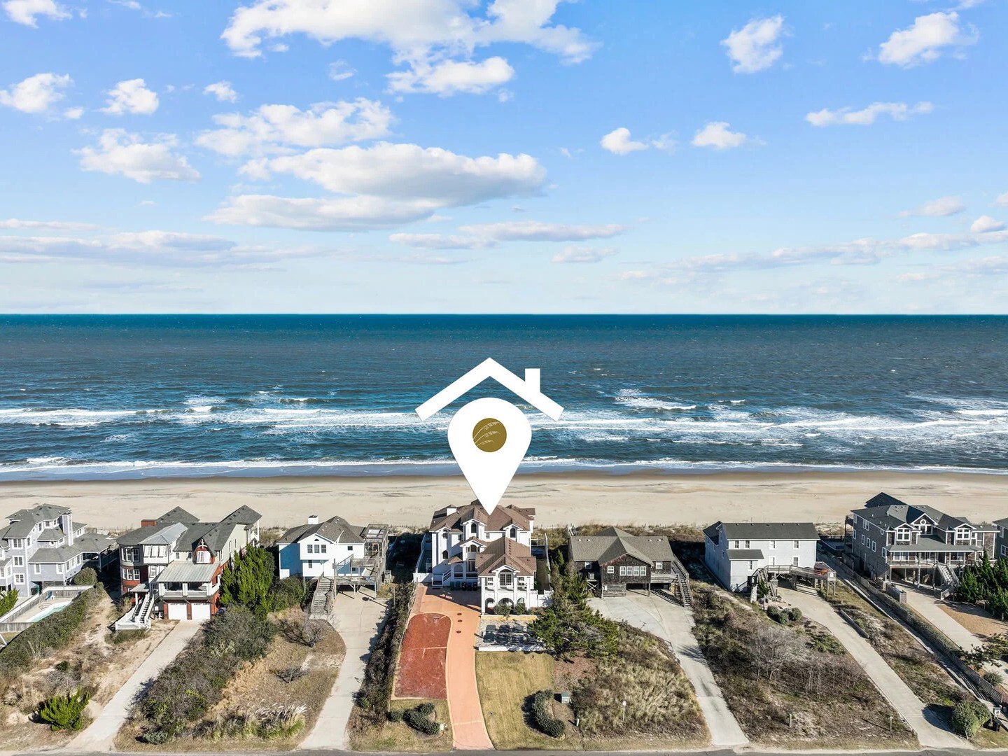 Aerial view of beach houses with a location icon over one.