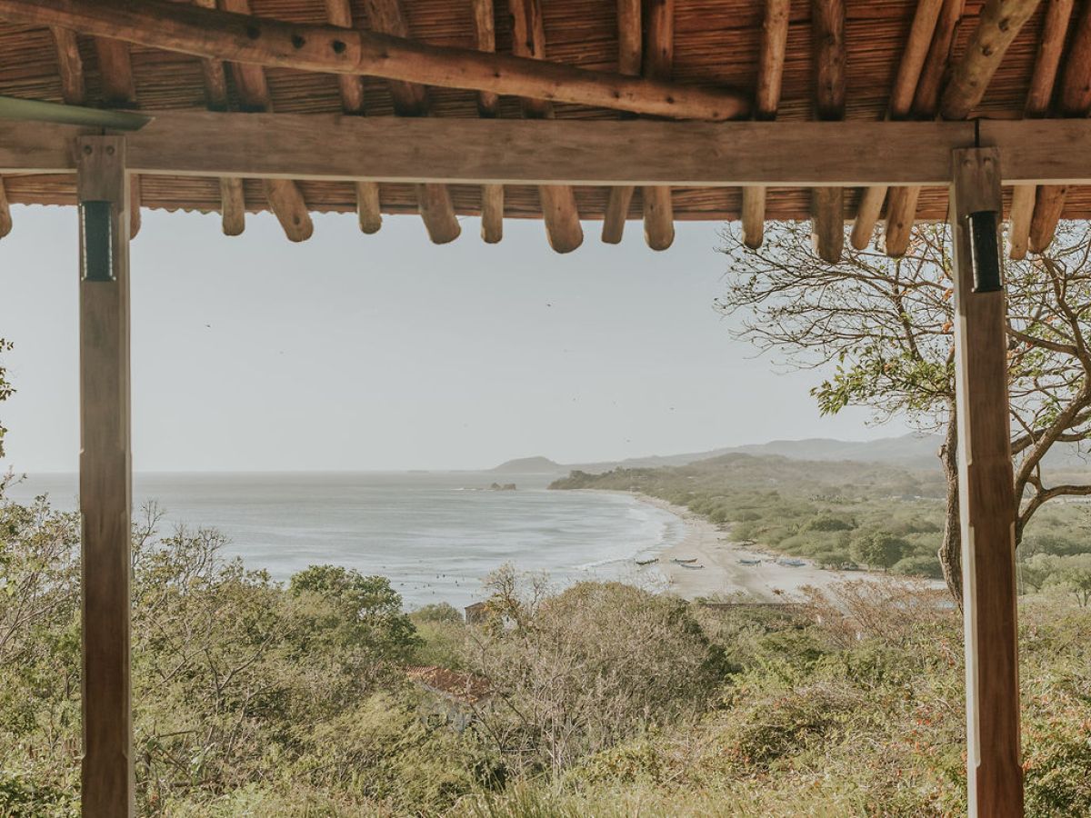 Wooden deck with yoga mats overlooking a scenic coastal view.
