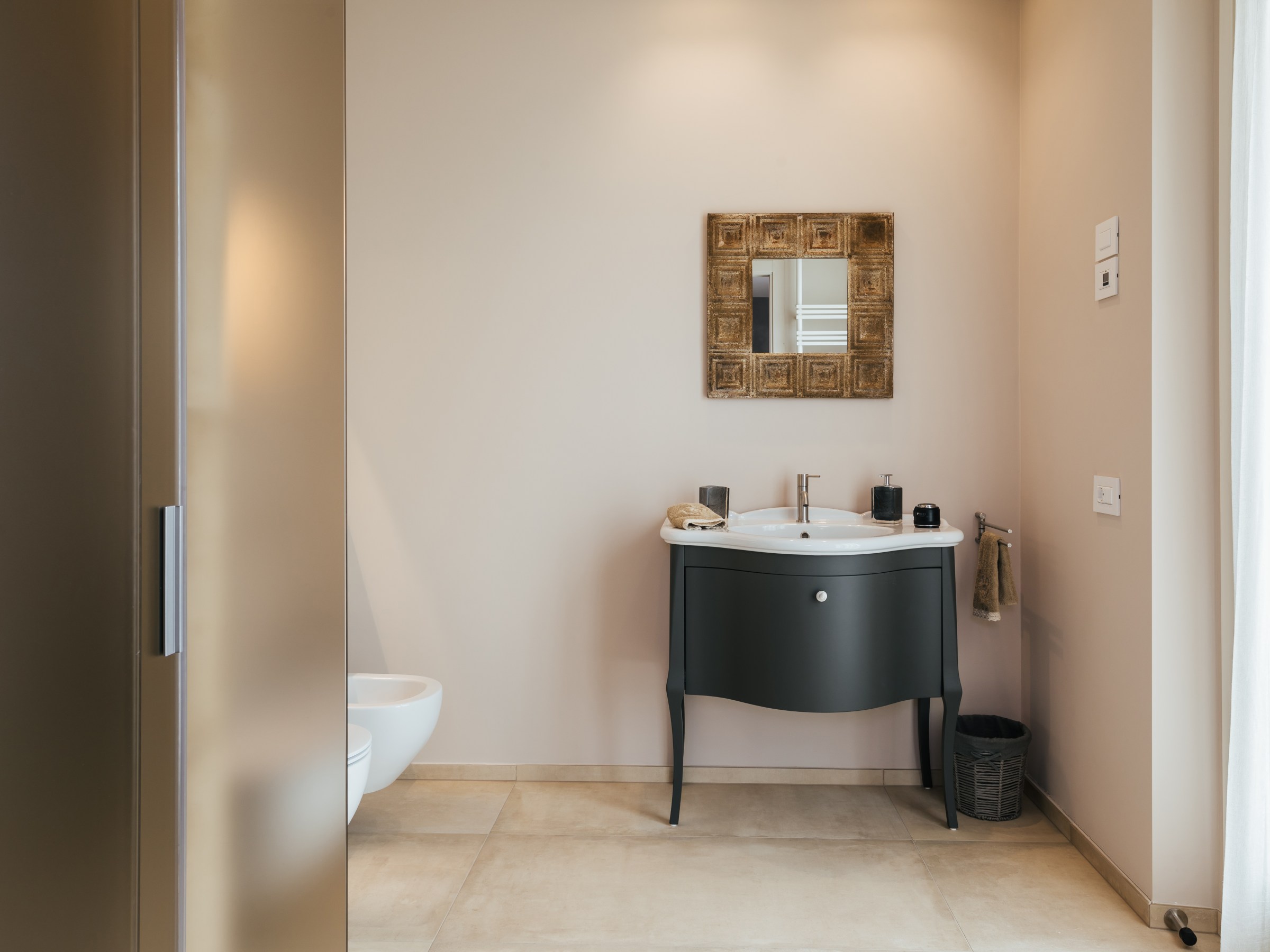 Minimalist bathroom with oval sink, mirror, and light beige walls.