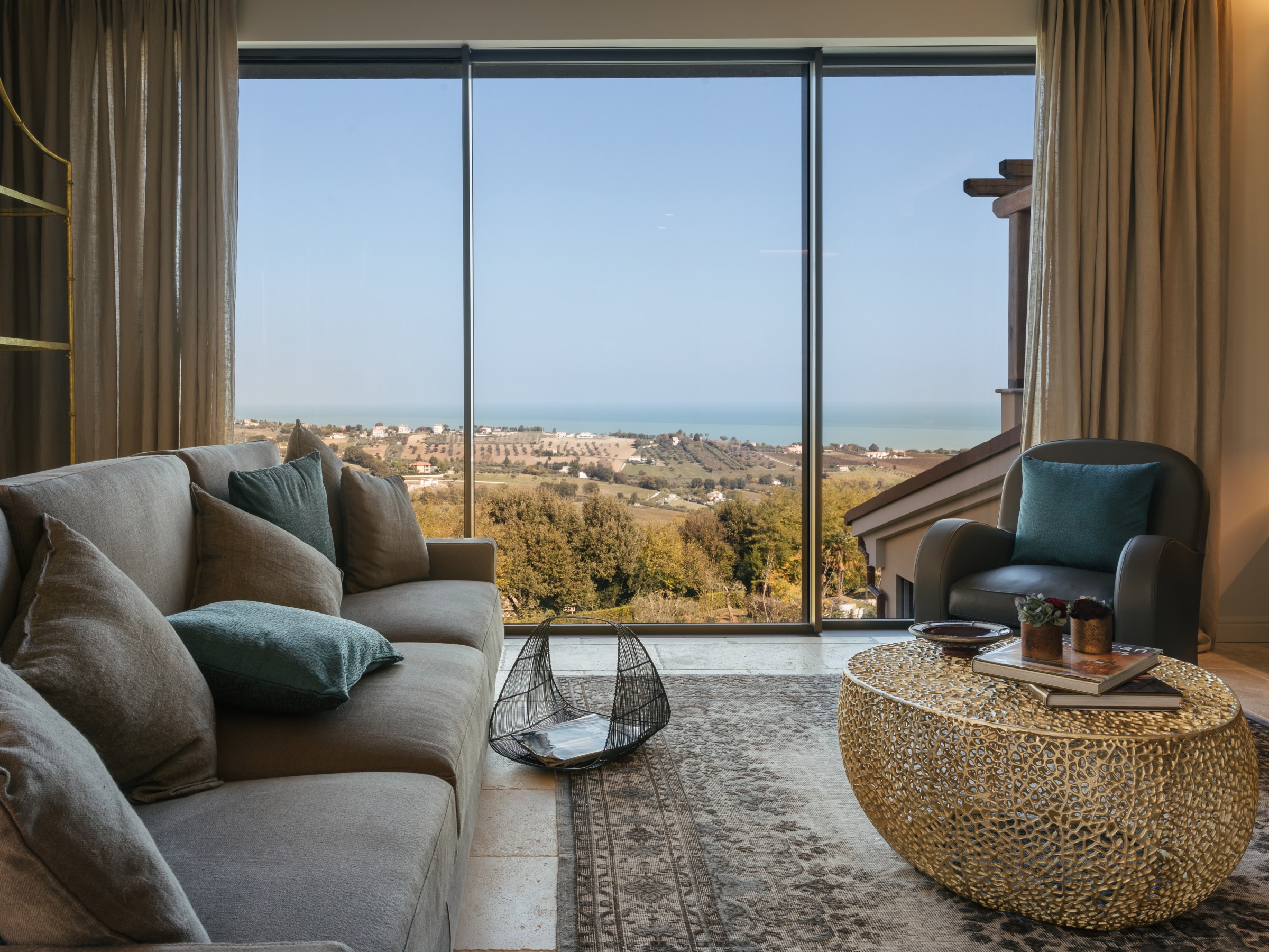 Cozy living room with large window, sea view, and modern furniture.