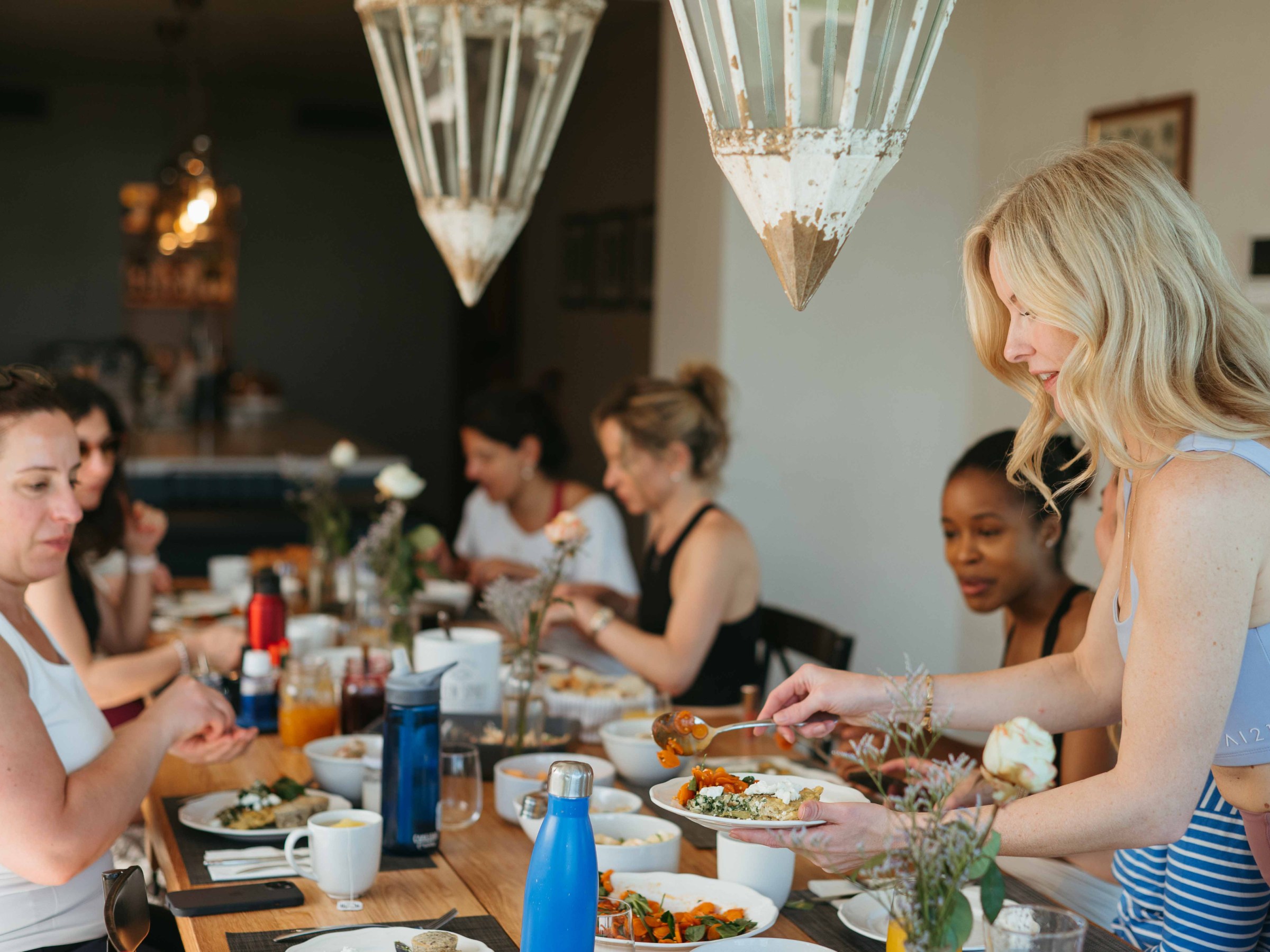 Group of women sharing a meal around a dining table.