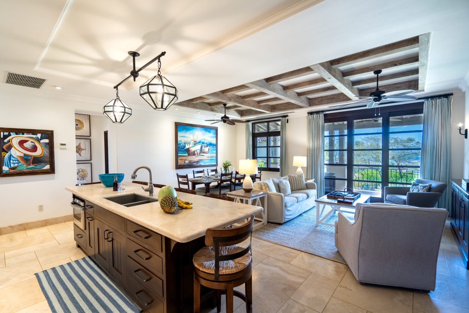 Open-concept kitchen and living room with modern decor and large windows.
