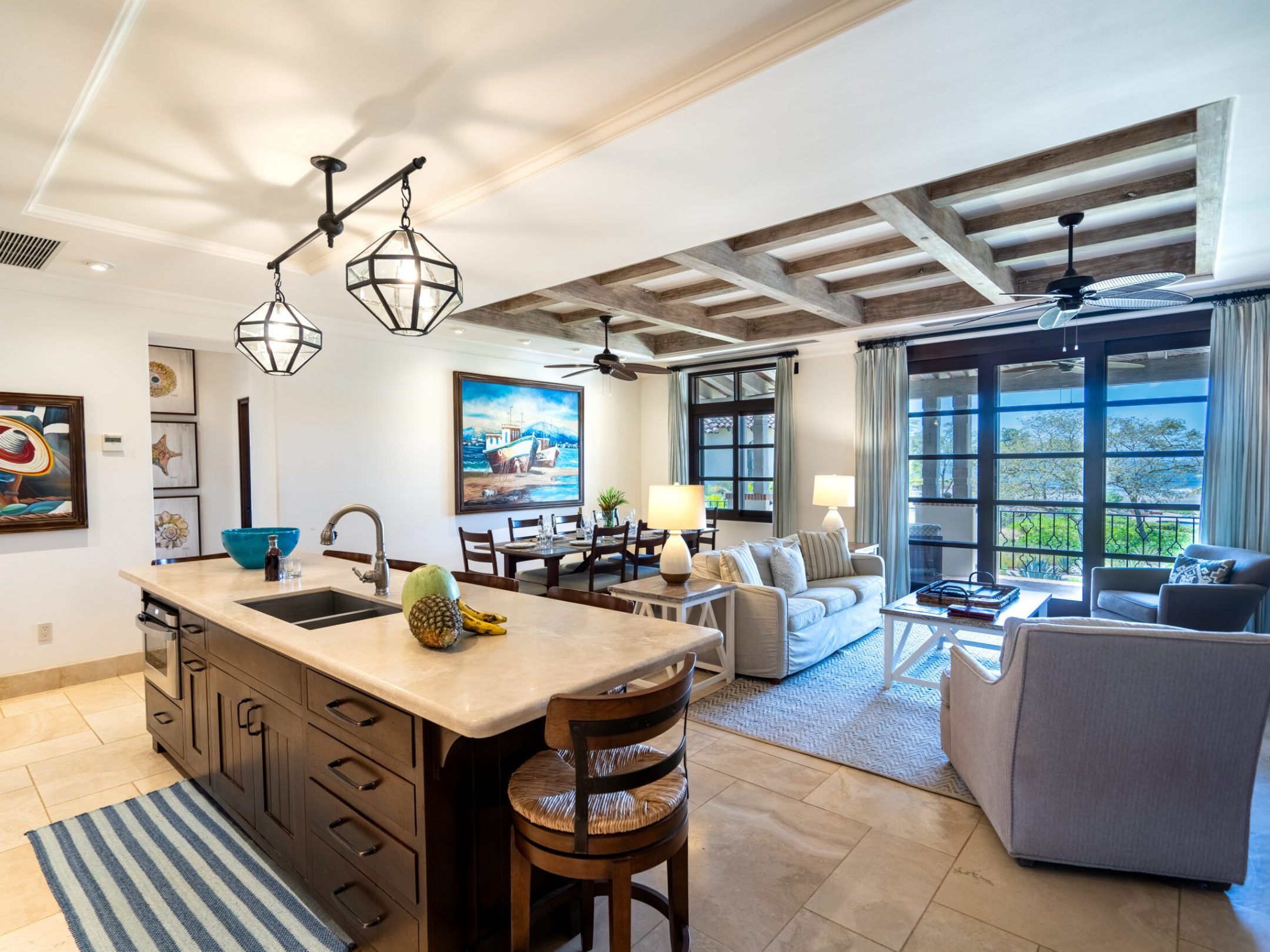 Open-concept kitchen and living room with modern decor and large windows.