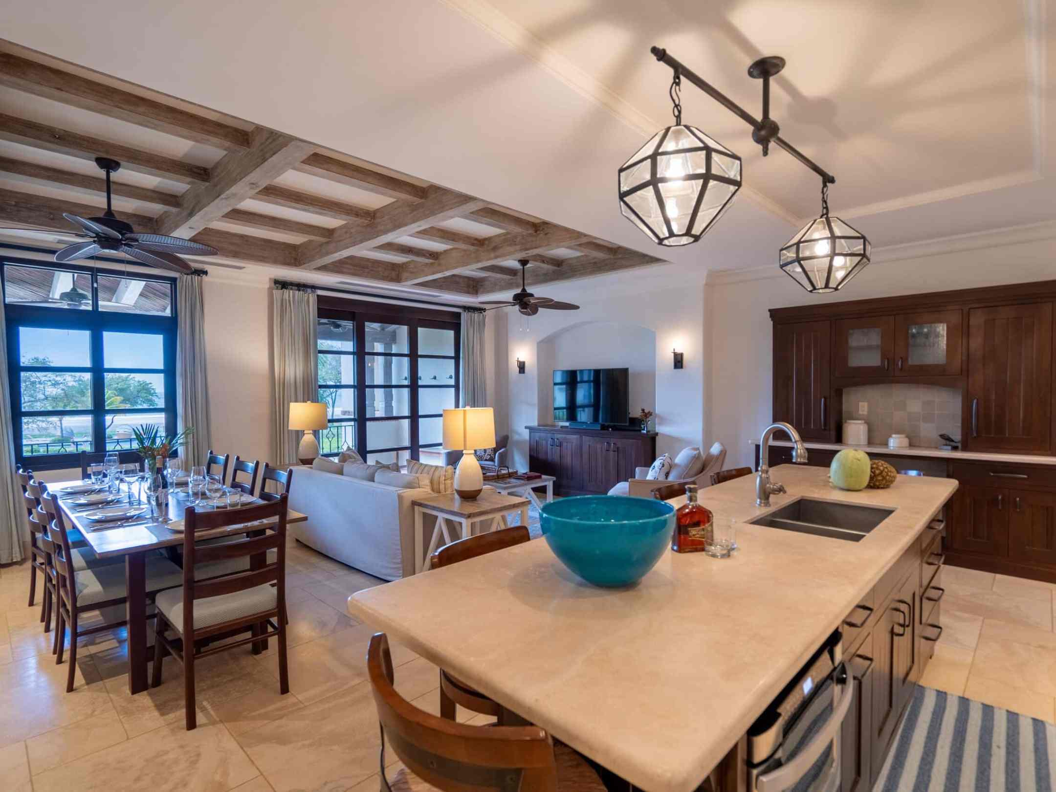 Spacious kitchen and living area with island, dining table, and large windows.