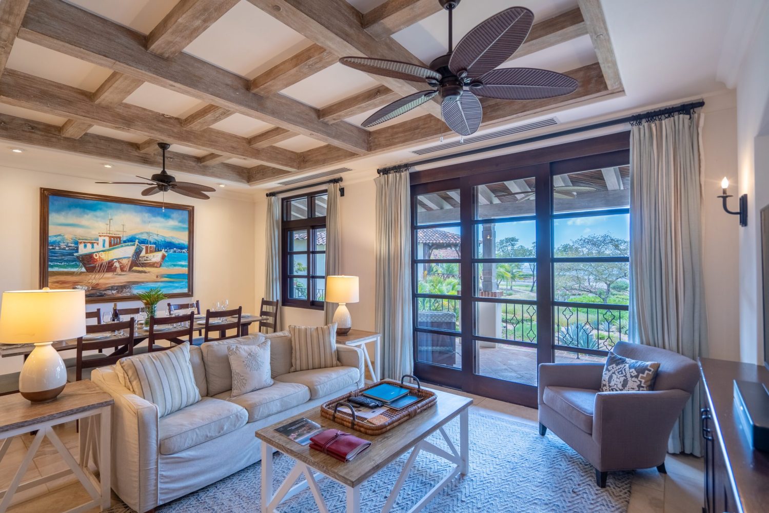 Cozy living room with sofas, armchair, ceiling fan, and a painting on the wall.