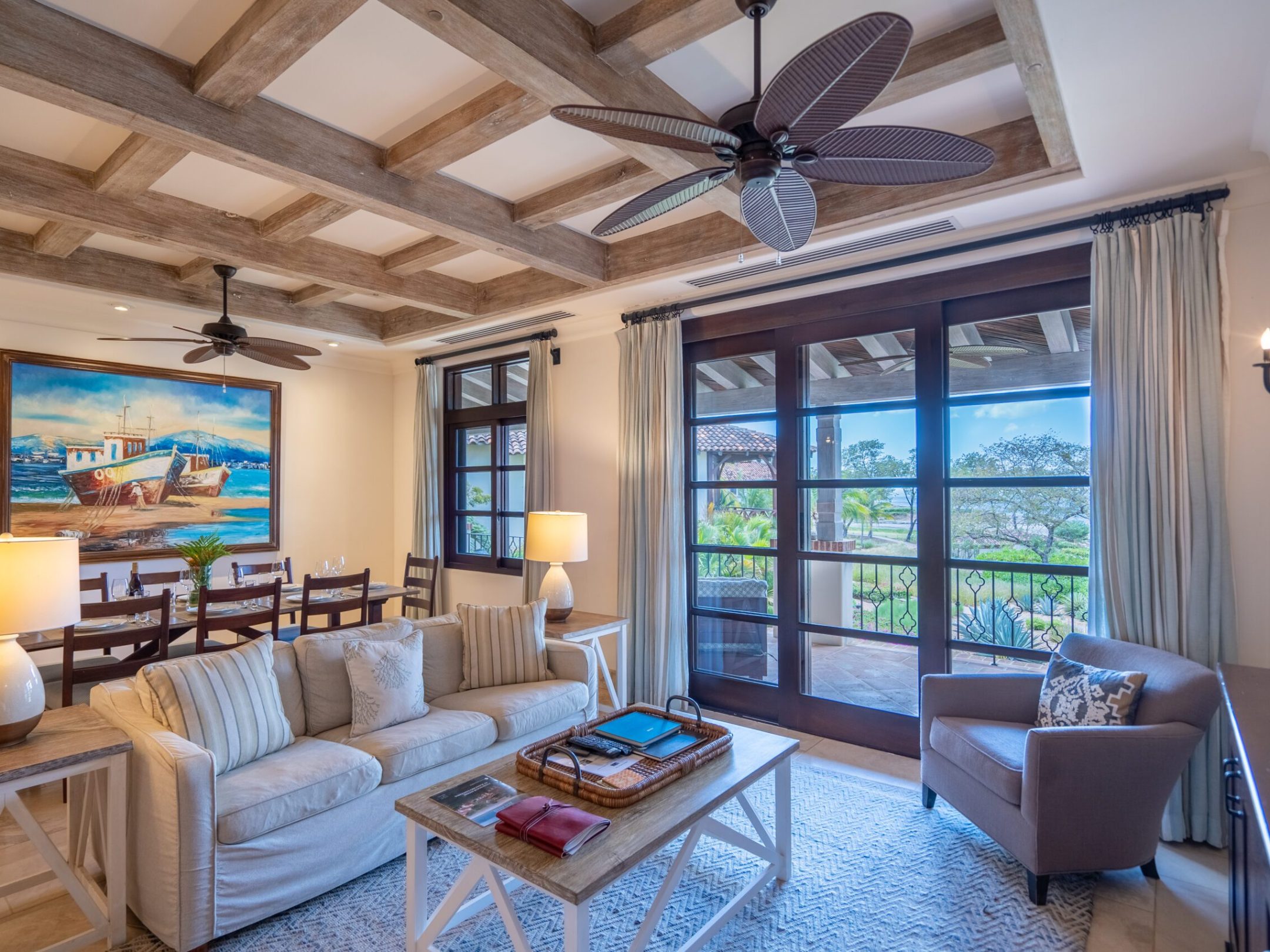 Cozy living room with sofas, armchair, ceiling fan, and a painting on the wall.